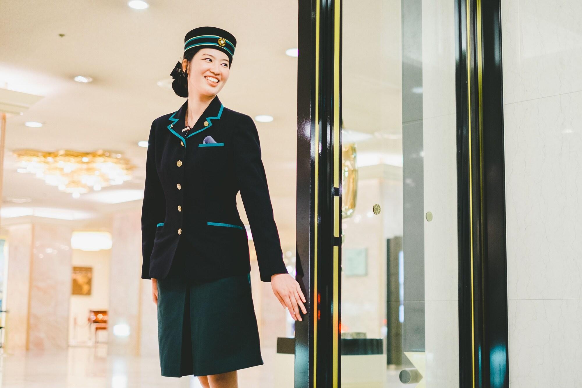 博多新大谷酒店 福岡 外观 照片 A female doorman at the entrance of a hotel